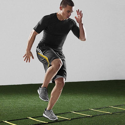 Man using AgiliStep agility ladder on grass to improve speed and coordination.